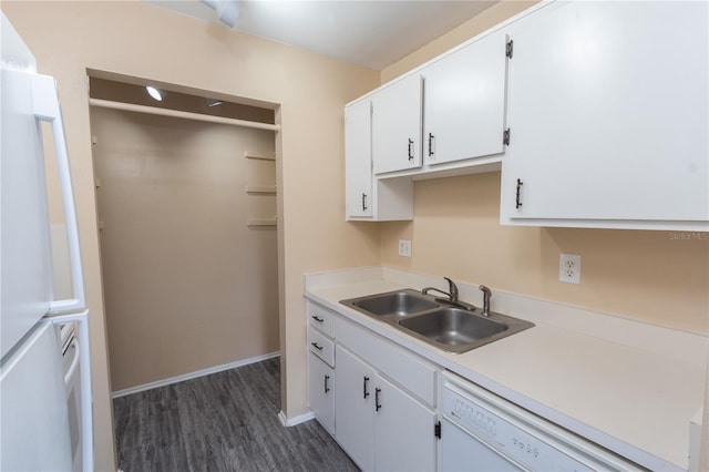 kitchen featuring dark wood-style flooring, light countertops, white cabinetry, a sink, and dishwasher