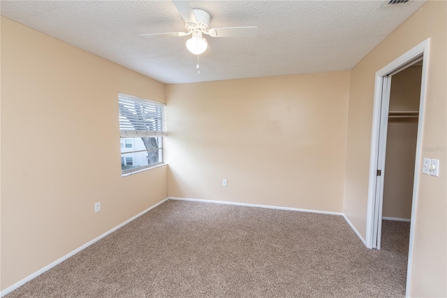 unfurnished bedroom featuring baseboards, carpet flooring, and a walk in closet