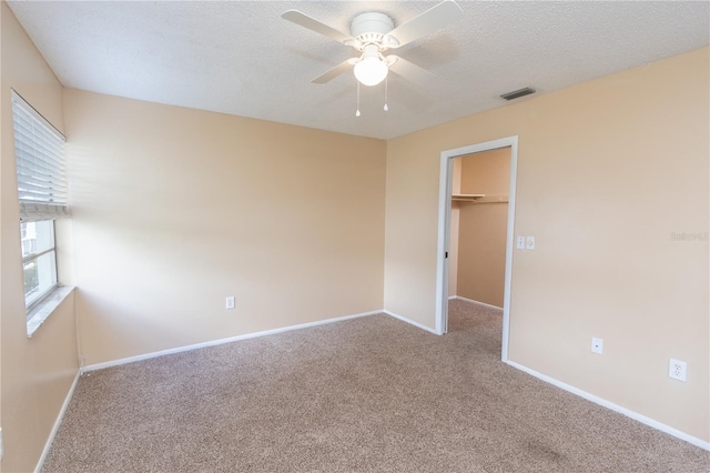 unfurnished bedroom featuring visible vents, baseboards, carpet floors, and a spacious closet