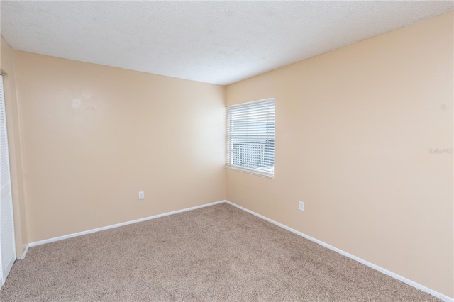 unfurnished room featuring baseboards and carpet