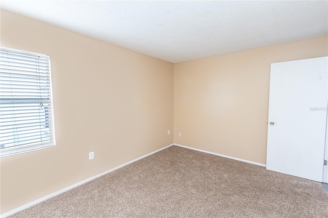 unfurnished room featuring baseboards and carpet