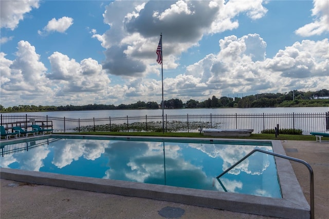 pool with a water view and fence