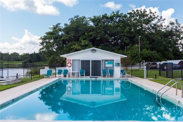 pool with a yard, a patio area, fence, and an outbuilding