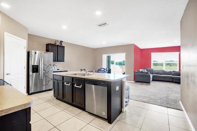 kitchen featuring appliances with stainless steel finishes, light carpet, a sink, plenty of natural light, and visible vents