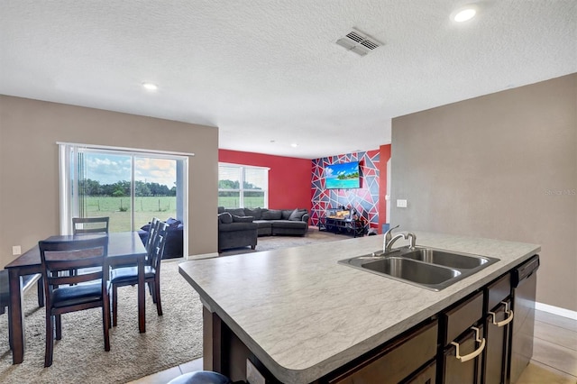 kitchen with visible vents, a center island with sink, a sink, dishwashing machine, and recessed lighting