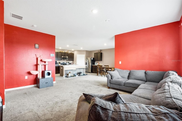 living area featuring recessed lighting, baseboards, visible vents, and light carpet