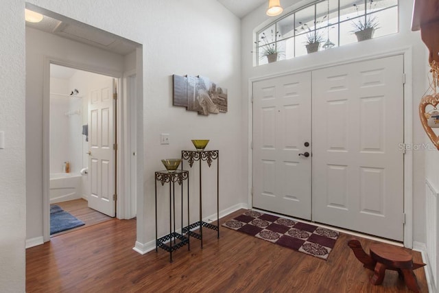 foyer featuring baseboards and dark wood-type flooring