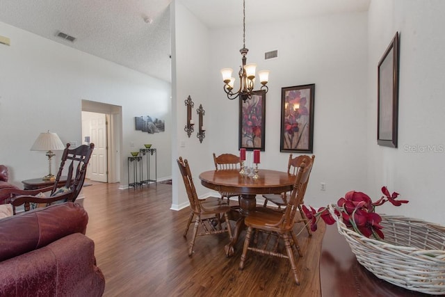 dining space with baseboards, an inviting chandelier, visible vents, and wood finished floors