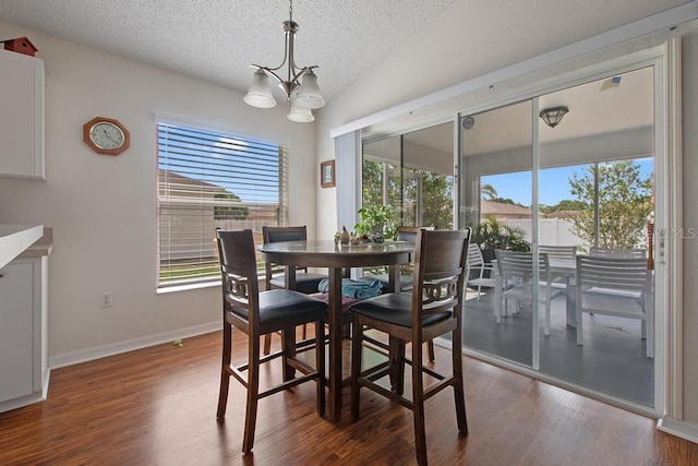 dining space featuring an inviting chandelier, plenty of natural light, and dark wood-type flooring