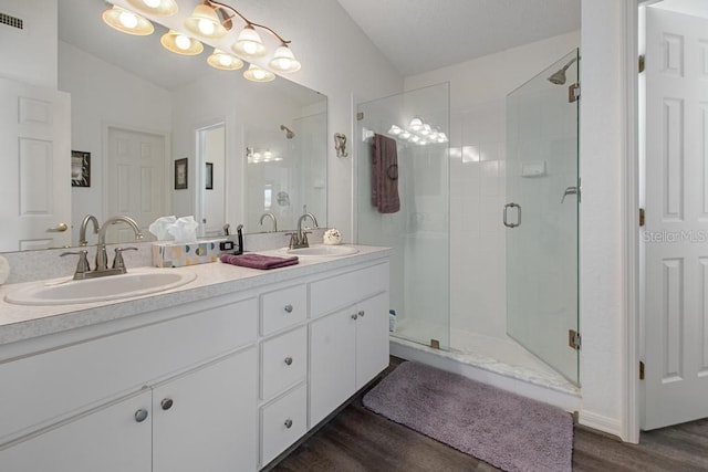 full bath featuring wood finished floors, a shower stall, and a sink