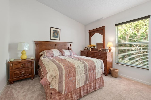 bedroom with vaulted ceiling, light carpet, and baseboards