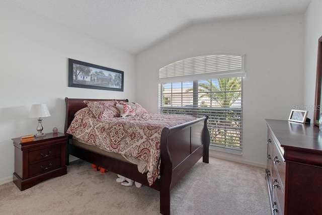 bedroom with vaulted ceiling, light colored carpet, and baseboards