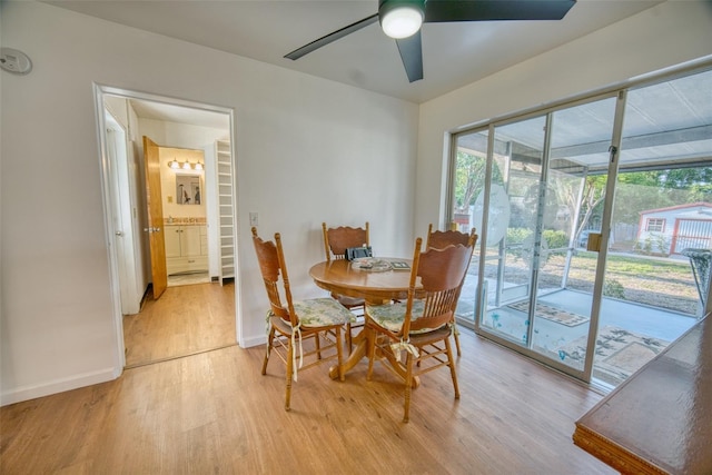 dining space with light wood finished floors, baseboards, and a ceiling fan