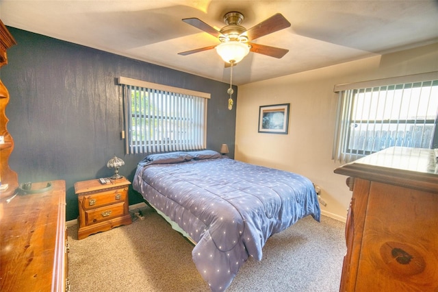 carpeted bedroom with ceiling fan and baseboards