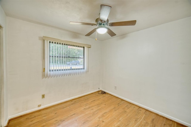 empty room with ceiling fan, baseboards, and wood finished floors