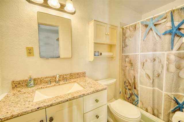 bathroom featuring vanity, toilet, a textured wall, and a shower with curtain