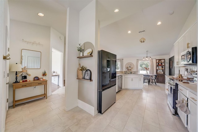 kitchen featuring a notable chandelier, light countertops, appliances with stainless steel finishes, and white cabinetry