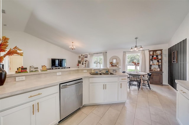 kitchen with stainless steel dishwasher, a sink, a chandelier, vaulted ceiling, and light countertops
