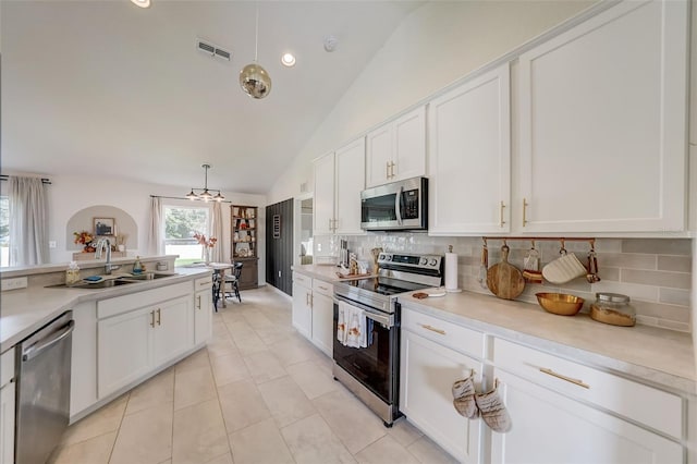 kitchen featuring a sink, stainless steel appliances, visible vents, decorative backsplash, and light countertops