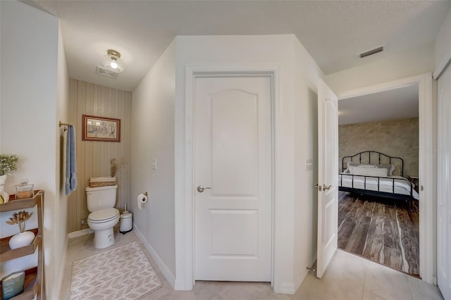bathroom featuring tile patterned floors, toilet, visible vents, and baseboards