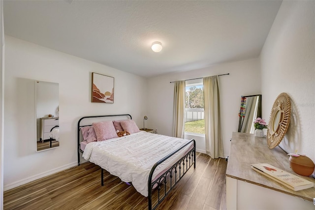 bedroom featuring baseboards and wood finished floors