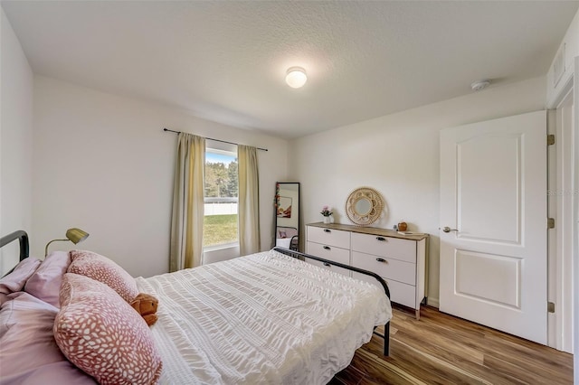 bedroom with visible vents and wood finished floors