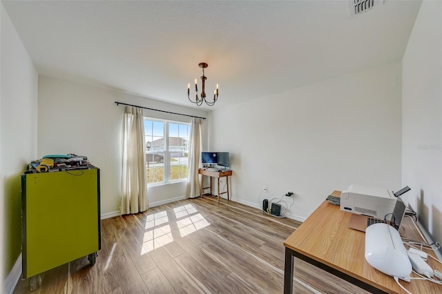 office featuring an inviting chandelier, baseboards, visible vents, and wood finished floors
