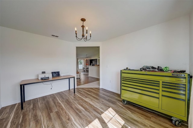 dining area with visible vents, wood finished floors, baseboards, and a notable chandelier