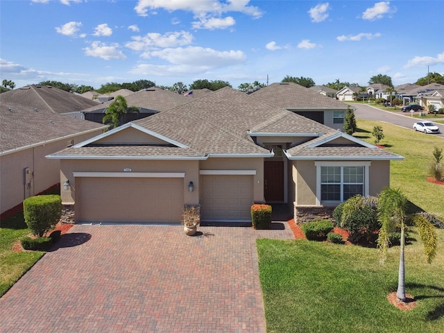 view of front of home with roof with shingles, an attached garage, decorative driveway, and stucco siding