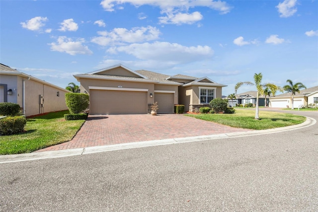 view of front of property featuring a garage, stucco siding, decorative driveway, and a front yard