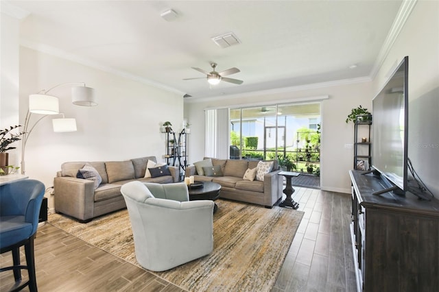 living room featuring crown molding, ceiling fan, wood finished floors, and visible vents