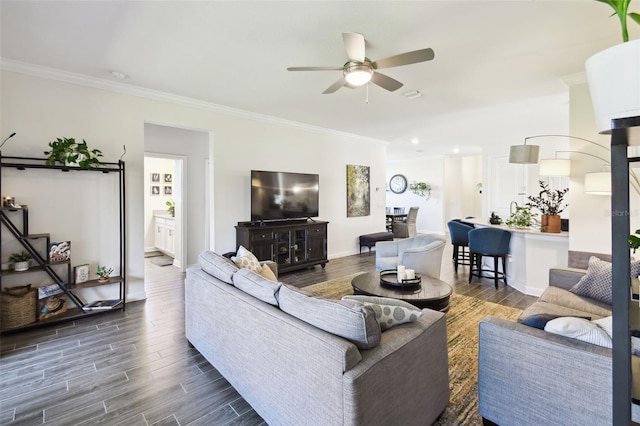living room featuring a ceiling fan, baseboards, ornamental molding, and wood finished floors