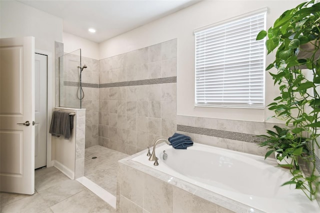 bathroom featuring tile patterned flooring, a walk in shower, and a bath