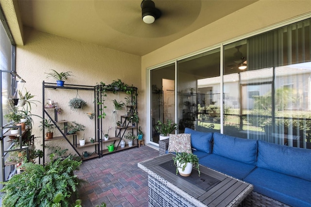 sunroom / solarium featuring ceiling fan and an outdoor living space