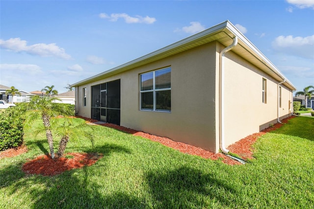 rear view of property with stucco siding and a yard