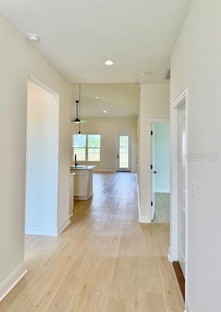 5275 Pebble Beach Dr, Sebring, FL 33872 - corridor with baseboards, recessed lighting, and light wood-style flooring