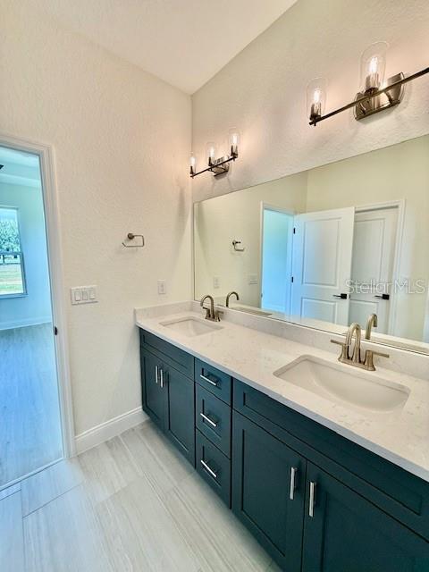 5275 Pebble Beach Dr, Sebring, FL 33872 - full bathroom with double vanity, baseboards, and a sink