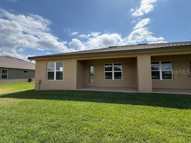 5275 Pebble Beach Dr, Sebring, FL 33872 - rear view of house with a lawn, stucco siding, and a patio area