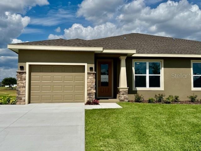 prairie-style house with an attached garage, stucco siding, concrete driveway, and a front lawn