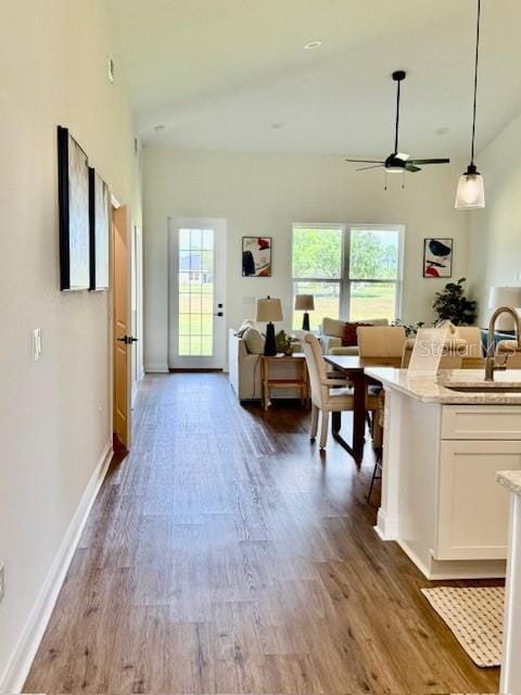 interior space featuring baseboards, ceiling fan, and wood finished floors