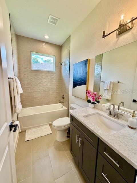 bathroom with tile patterned flooring, vanity, shower / bathtub combination, toilet, and visible vents