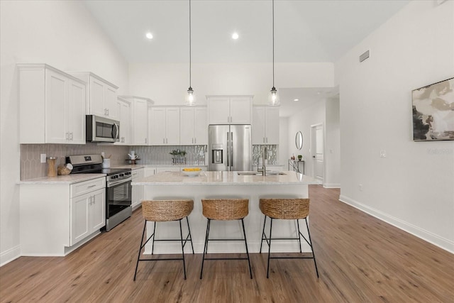 5277 Pebble Beach Dr, Sebring, FL 33872 - kitchen with stainless steel appliances, white cabinets, a kitchen breakfast bar, tasteful backsplash, and recessed lighting