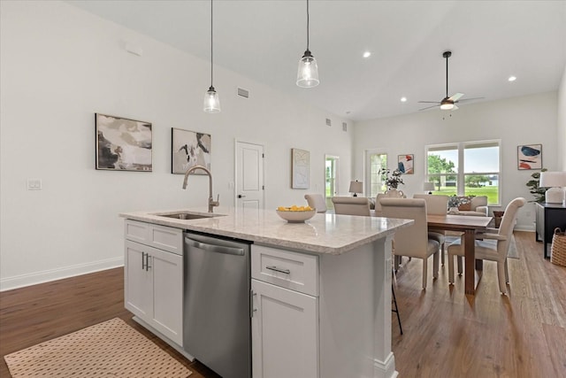5277 Pebble Beach Dr, Sebring, FL 33872 - kitchen with dishwasher, open floor plan, white cabinetry, wood finished floors, and a center island with sink