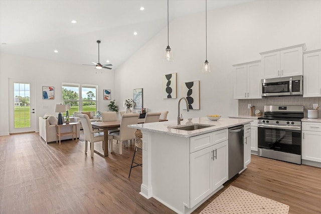 5277 Pebble Beach Dr, Sebring, FL 33872 - kitchen with stainless steel appliances, high vaulted ceiling, ceiling fan, open floor plan, and tasteful backsplash