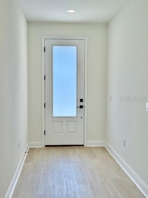 5273 Pebble Beach Dr, Sebring, FL 33872 - doorway with baseboards and light wood-type flooring