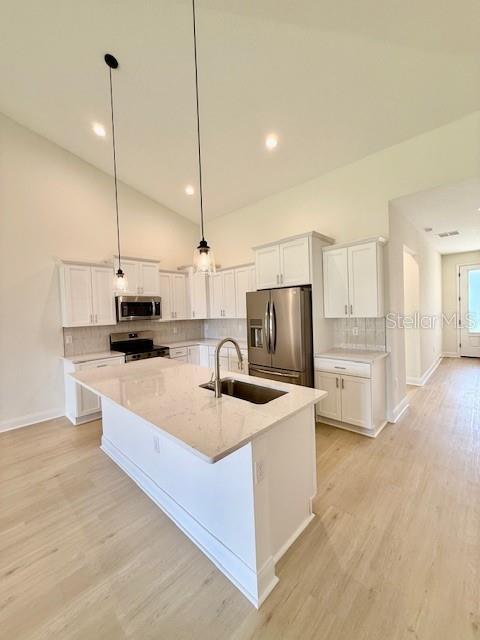 5273 Pebble Beach Dr, Sebring, FL 33872 - kitchen featuring a sink, a center island with sink, white cabinets, and stainless steel appliances