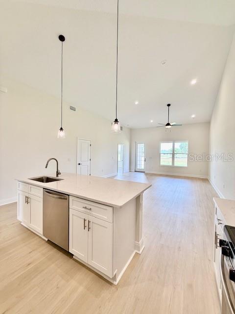 5273 Pebble Beach Dr, Sebring, FL 33872 - kitchen with a ceiling fan, stove, dishwasher, a sink, and light wood finished floors
