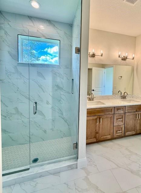 5273 Pebble Beach Dr, Sebring, FL 33872 - full bath with double vanity, a marble finish shower, a sink, and marble finish floor