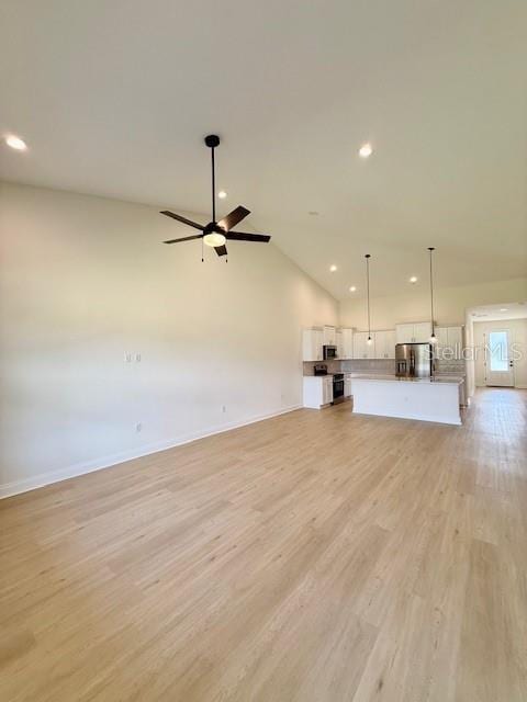 5273 Pebble Beach Dr, Sebring, FL 33872 - unfurnished living room with ceiling fan, recessed lighting, baseboards, lofted ceiling, and light wood-type flooring