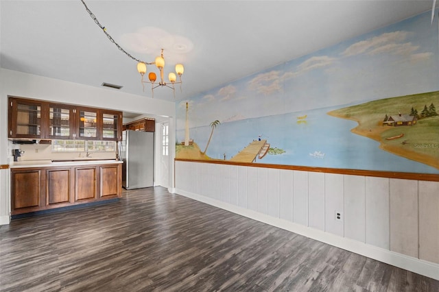 interior space featuring freestanding refrigerator, baseboards, visible vents, dark wood finished floors, and a notable chandelier